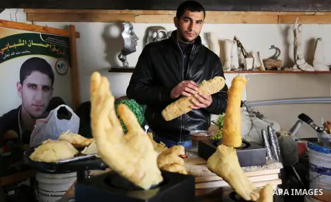 Palestinian artist, Mohammed Abu Hashish, 29, uses beeswax to produce models of human limb, at his workshop, in the al-Maghazi refugee camp, in the centre of the Gaza Strip, on February 27, 2017. Photo by Ashraf Amra