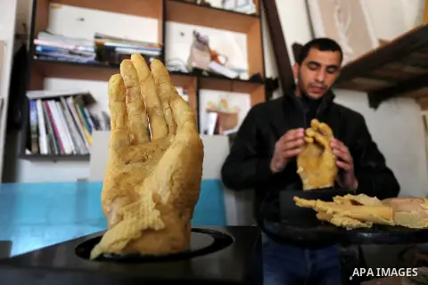 Palestinian artist, Mohammed Abu Hashish, 29, uses beeswax to produce models of human limb, at his workshop, in the al-Maghazi refugee camp, in the centre of the Gaza Strip, on February 27, 2017. Photo by Ashraf Amra