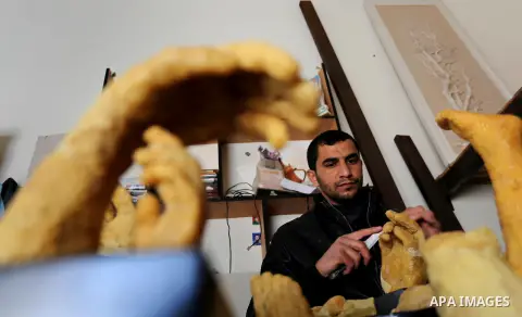 Palestinian artist, Mohammed Abu Hashish, 29, uses beeswax to produce models of human limb, at his workshop, in the al-Maghazi refugee camp, in the centre of the Gaza Strip, on February 27, 2017. Photo by Ashraf Amra