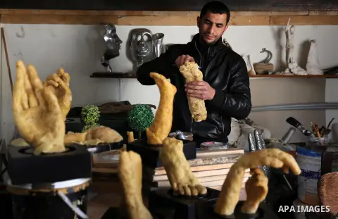 Palestinian artist, Mohammed Abu Hashish, 29, uses beeswax to produce models of human limb, at his workshop, in the al-Maghazi refugee camp, in the centre of the Gaza Strip, on February 27, 2017. Photo by Ashraf Amra