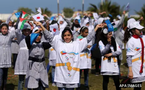 Palestinian schoolgirls fly kites to show solidarity with the Japanese people during an event organised by the United Nations Relief and Works Agency (UNRWA) to mark the the sixth anniversary of the Tohoku earthquake and...