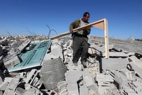 A Palestinian man looks for his belongings amongst the rubble of her house after it was demolished by the Israeli army as it did not have an Israeli-issued construction permit, in the West Bank city of Hebron March 6, 20...