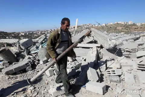 A Palestinian man looks for his belongings amongst the rubble of her house after it was demolished by the Israeli army as it did not have an Israeli-issued construction permit, in the West Bank city of Hebron March 6, 20...