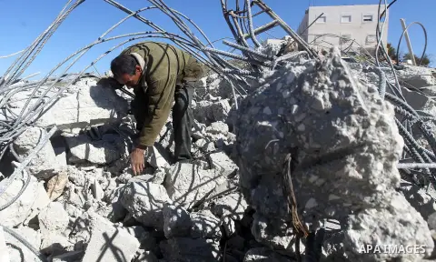 A Palestinian man looks for his belongings amongst the rubble of her house after it was demolished by the Israeli army as it did not have an Israeli-issued construction permit, in the West Bank city of Hebron March 6, 20...