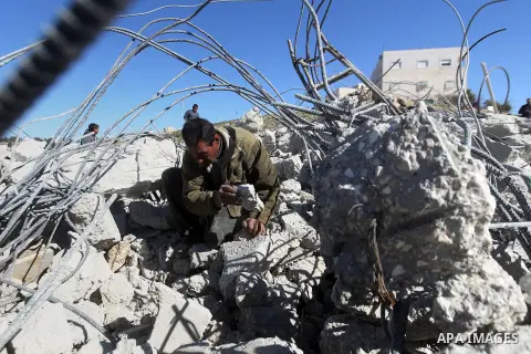 A Palestinian man looks for his belongings amongst the rubble of her house after it was demolished by the Israeli army as it did not have an Israeli-issued construction permit, in the West Bank city of Hebron March 6, 20...