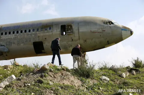 Palestinian taxi vans walk near a retired Boeing airplane once belonging to an Israeli airline has standing in an empty ground in the west bank city of Nablus, on March 7, 2017. Photo by Wisam Hashlamoun