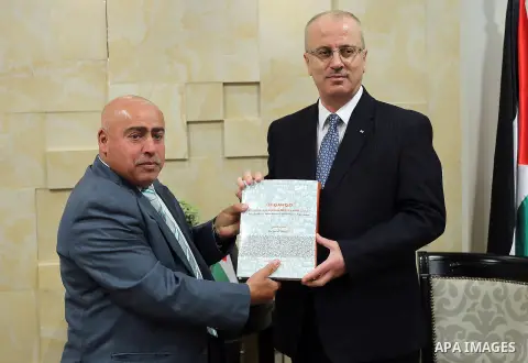 Palestinian Prime Minister Rami Hamdallah, receives The annual report of Abu Jihad Center for Prisoners Affairs, in the West Bank, city of Ramallah, on March 12, 2017. Photo by Prime Minister Office
