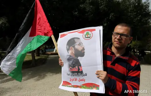 Palestinian supporters of the Popular Front for the Liberation of Palestine (PFLP), hold placards during a protest against the trial of the martyr, Bassel al-Aaraj, and the security coordination in Gaza City, on March 12...