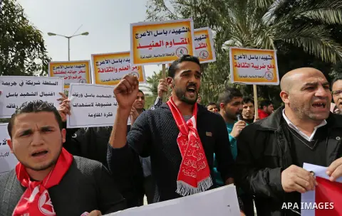 Palestinian supporters of the Popular Front for the Liberation of Palestine (PFLP), hold placards during a protest against the trial of the martyr, Bassel al-Aaraj, and the security coordination in Gaza City, on March 12...
