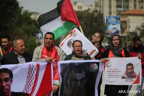 Palestinian supporters of the Popular Front for the Liberation of Palestine (PFLP), hold placards during a protest against the trial of the martyr, Bassel al-Aaraj, and the security coordination in Gaza City, on March 12...