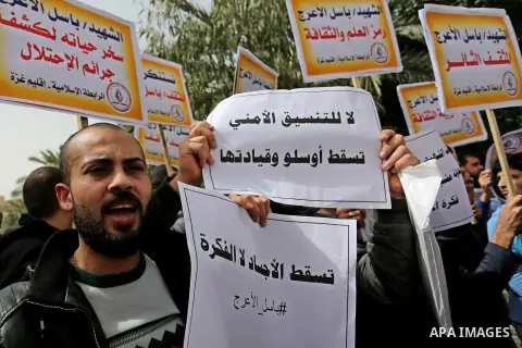 Palestinian supporters of the Popular Front for the Liberation of Palestine (PFLP), hold placards during a protest against the trial of the martyr, Bassel al-Aaraj, and the security coordination in Gaza City, on March 12...