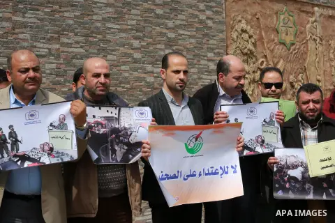 Palestinian journalists hold placards during a protest to show solidarity with their colleges in the West Bank, in front of the Legislative Council, in Gaza city on March 13, 2017. Photo by Mohammed Asad