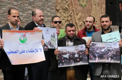 Palestinian journalists hold placards during a protest to show solidarity with their colleges in the West Bank, in front of the Legislative Council, in Gaza city on March 13, 2017. Photo by Mohammed Asad
