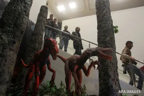 Visitors look at a model of the Polacanthus Dinosaurs during the opening ceremony of the Baby Dinosaurs and Giant Insect Exhibition, in the West Bank city of Bethlehem, Tuesday, March 14, 2017. The exhibition was donated...