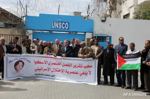 Palestinians hold banners during a protest against the U.N. Secretary-General Antonio Guterres decision to remove Israeli 'apartheid' report from Economic and Social Commission for Western Asia (ESCWA) website, in front...