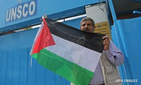 Palestinians hold banners during a protest against the U.N. Secretary-General Antonio Guterres decision to remove Israeli 'apartheid' report from Economic and Social Commission for Western Asia (ESCWA) website, in front...