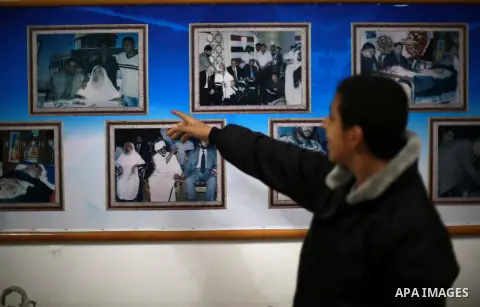 A Palestinian youth walks past pictures for late Hamas leader Sheikh Ahmed Yassin who was killed in an Israeli attack, in his house marking the thirteenth anniversary of his death, in Gaza City, March 21, 2017. Photo by...