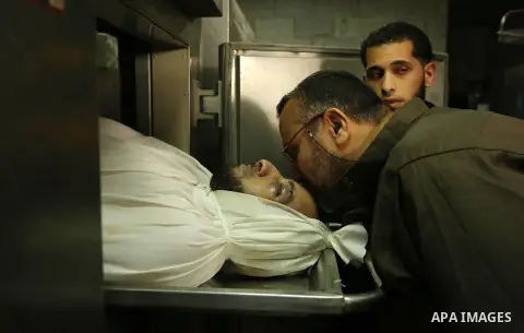 A Palestinian man kisses the head of Hamas official, Mazen Faqha who was freed by Israel in a 2011 prisoner swap at a hospital morgue in Gaza City March 25, 2017. Faqha was released along with more than 1,000 other Pales...