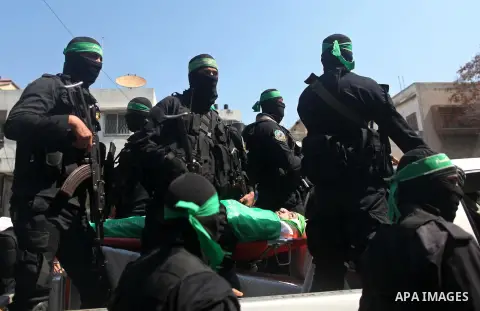 Members of the Ezzedine al-Qassam Brigades, the military wing of the Palestinian Islamist movement Hamas carry the body of Hamas official, Mazen Faqha who was freed by Israel in a 2011 prisoner swap during his funeral in...