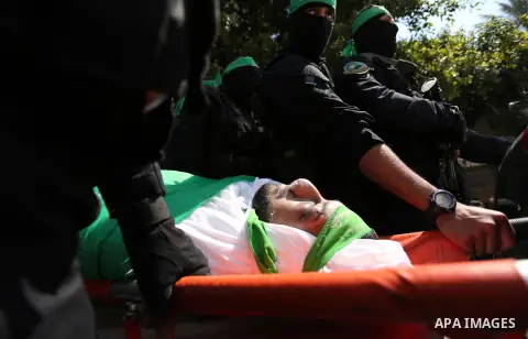 Members of the Ezzedine al-Qassam Brigades, the military wing of the Palestinian Islamist movement Hamas carry the body of Hamas official, Mazen Faqha who was freed by Israel in a 2011 prisoner swap during his funeral in...