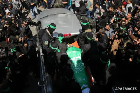 Members of the Ezzedine al-Qassam Brigades, the military wing of the Palestinian Islamist movement Hamas carry the body of Hamas official, Mazen Faqha who was freed by Israel in a 2011 prisoner swap during his funeral in...