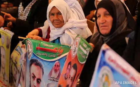 Palestinians hold placards during a protest to show solidarity with Palestinian prisoners held in Israeli Jails, in front of Red cross office in Gaza city, on March 27, 2017. Photo by Ashraf Amra