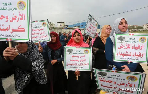 Palestinians hold banners and Palestine flags during a rally marking Land Day, near the Israeli border with northern Gaza Strip March 30, 2017. March 30 marks Land Day, the annual commemorations of the killing by police...