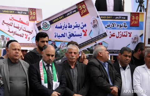 Palestinians hold banners and Palestine flags during a rally marking Land Day, near the Israeli border with northern Gaza Strip March 30, 2017. March 30 marks Land Day, the annual commemorations of the killing by police...