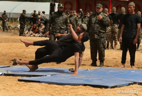 Palestinian high-school students show off their skills during a graduation ceremony from a military school course organised by the Palestinian security forces in Gaza strip, in Gaza City, on April 2, 2017. Photo by Ashra...