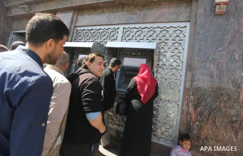 Palestinian employees paid by the Palestinian Authority wait to receive their salaries from an ATM, outside a Bank in Gaza City April 5, 2017. The salaries of Palestinian employees in Gaza strip have been reduced by abou...