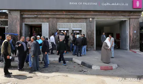 Palestinian employees paid by the Palestinian Authority wait to receive their salaries from an ATM, outside a Bank in Gaza City April 5, 2017. The salaries of Palestinian employees in Gaza strip have been reduced by abou...