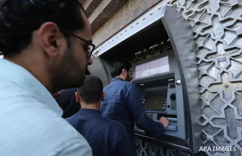 Palestinian employees paid by the Palestinian Authority wait to receive their salaries from an ATM, outside a Bank in Gaza City April 5, 2017. The salaries of Palestinian employees in Gaza strip have been reduced by abou...