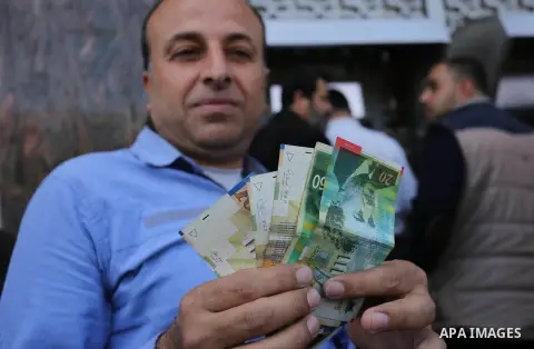 Palestinian employees paid by the Palestinian Authority wait to receive their salaries from an ATM, outside a Bank in Gaza City April 5, 2017. The salaries of Palestinian employees in Gaza strip have been reduced by abou...