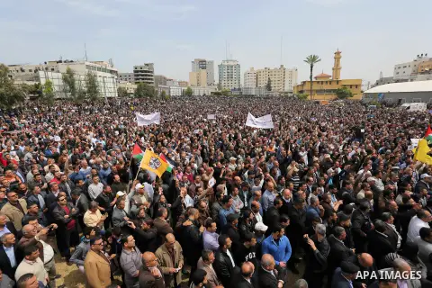 Palestinians, employed by the Palestinian Authority, chant slogans and wave placards during a demonstration against the decision to reduce their salaries in Gaza City on April 8, 2017. Photo by Ashraf Amra