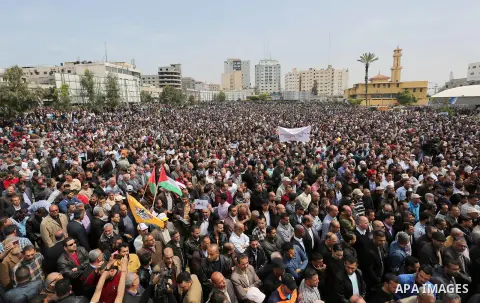 Palestinians, employed by the Palestinian Authority, chant slogans and wave placards during a demonstration against the decision to reduce their salaries in Gaza City on April 8, 2017. Photo by Ashraf Amra