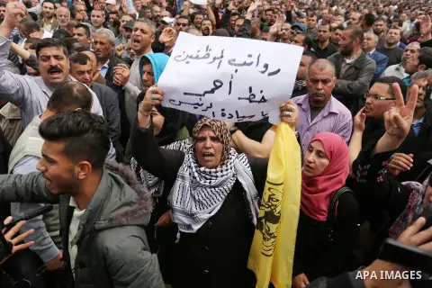Palestinians, employed by the Palestinian Authority, chant slogans and wave placards during a demonstration against the decision to reduce their salaries in Gaza City on April 8, 2017. Photo by Ashraf Amra