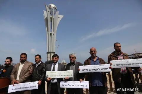 Palestinians hold placards during a protest to show solidarity with Palestinian prisoners held in Israeli Jails, in Gaza city, on April 9, 2017. Photo by Ashraf Amra