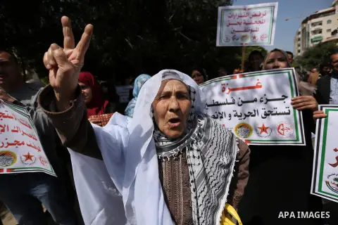 Palestinians employed by the Palestinian Authority, chant slogans and wave placards during a demonstration against the decision to reduce their salaries in Gaza City on April 11, 2017. Photo by Ashraf Amra