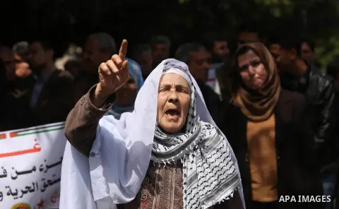 Palestinians employed by the Palestinian Authority, chant slogans and wave placards during a demonstration against the decision to reduce their salaries in Gaza City on April 11, 2017. Photo by Ashraf Amra