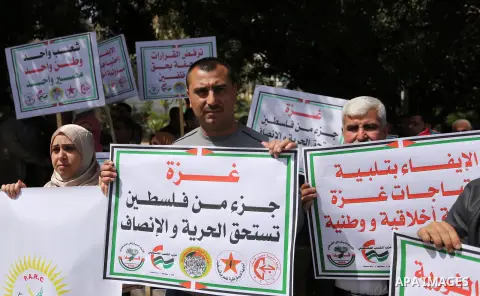 Palestinians employed by the Palestinian Authority, chant slogans and wave placards during a demonstration against the decision to reduce their salaries in Gaza City on April 11, 2017. Photo by Ashraf Amra