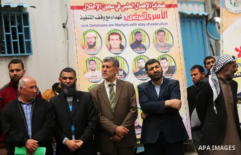 Palestinians hold placards during a protest to show solidarity with Palestinian prisoners held in Israeli Jails, in Gaza city, on April 12, 2017. Photo by Ashraf Amra