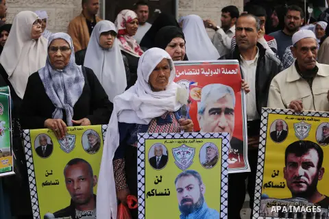 Palestinians hold placards during a protest to show solidarity with Palestinian prisoners held in Israeli Jails, in front of Red cross office in Gaza city, on April 17, 2017. Photo by Mohammed Asad