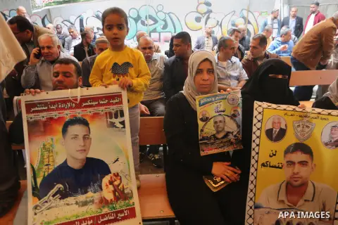 Palestinians hold placards during a protest to show solidarity with Palestinian prisoners held in Israeli Jails, in front of Red cross office in Gaza city, on April 17, 2017. Photo by Mohammed Asad