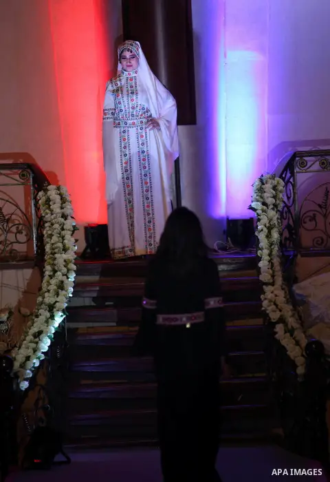 A picture taken on April 15, 2017 shows a Palestinian model displays a traditional Palestinian dress during a fashion show during the 2nd Nablus Festival for Culture and Arts, in the West Bank city of Nablus. The interna...