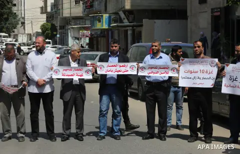 Union of the Palestinian syndicates members hold banners during a protest against Israeli blockade, in Gaza city, on April 19, 2017. Photo by Mohammed Asad