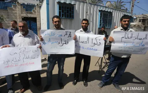 Union of the Palestinian syndicates members hold banners during a protest against Israeli blockade, in Gaza city, on April 19, 2017. Photo by Mohammed Asad