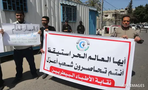 Union of the Palestinian syndicates members hold banners during a protest against Israeli blockade, in Gaza city, on April 19, 2017. Photo by Mohammed Asad