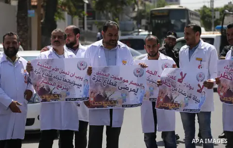 Union of the Palestinian syndicates members hold banners during a protest against Israeli blockade, in Gaza city, on April 19, 2017. Photo by Mohammed Asad