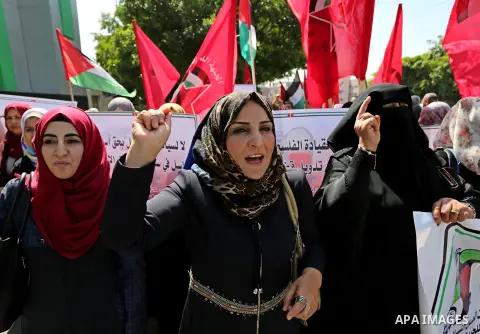 Palestinian supporters of the Democratic Front for the Liberation of Palestine (DFLP), hold banners during a protest to show solidarity with Palestinian prisoners on hunger strike in Israeli jails, in Gaza city on April...