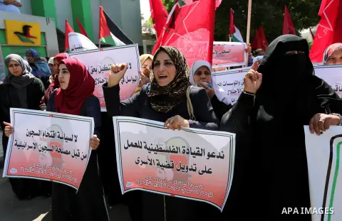Palestinian supporters of the Democratic Front for the Liberation of Palestine (DFLP), hold banners during a protest to show solidarity with Palestinian prisoners on hunger strike in Israeli jails, in Gaza city on April...